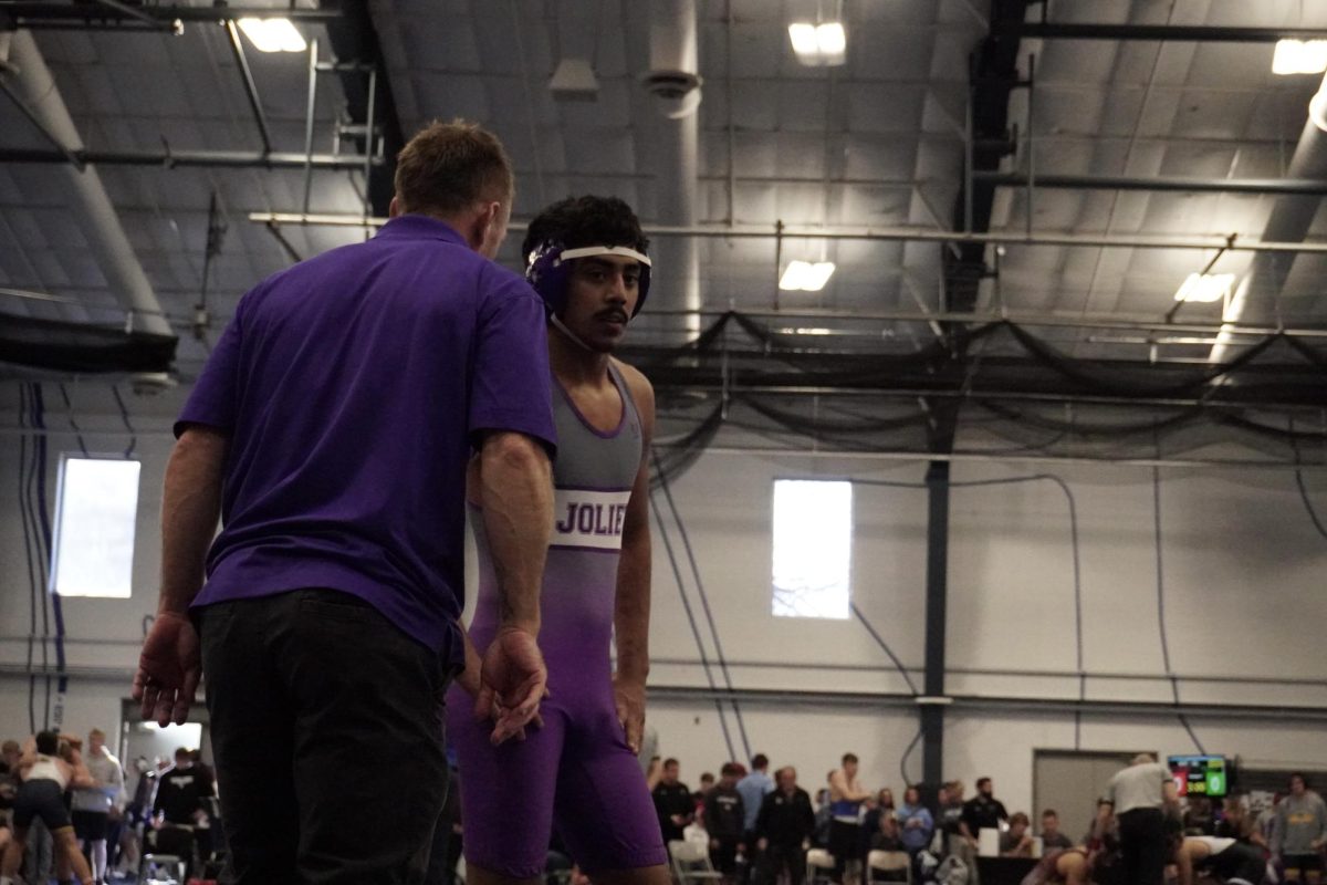Freshman 141-pound wrestler Adrian Hernandez warms up before a match.