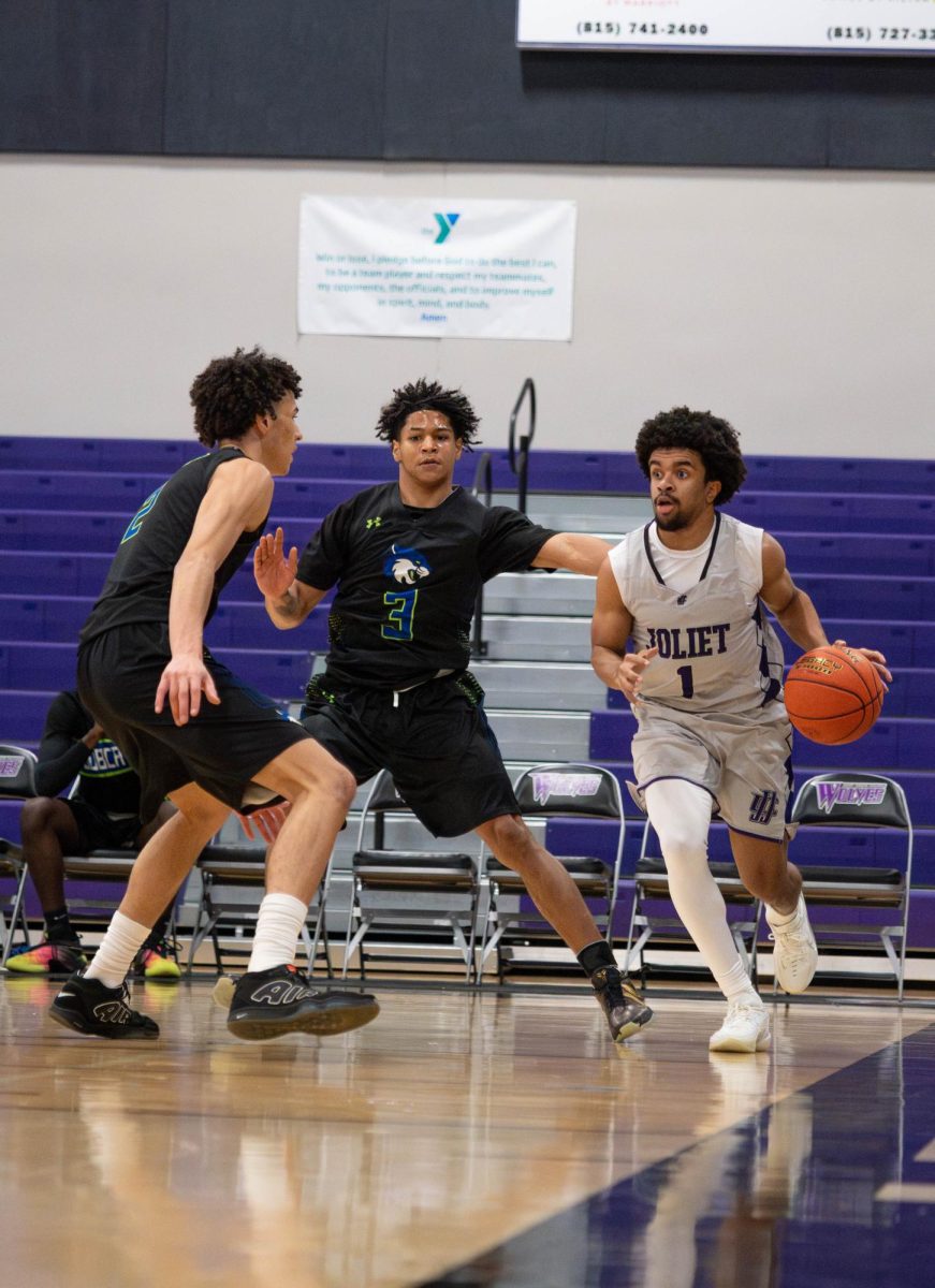 Ricky Hill goes up for a shot through defensive pressure against opposing team.