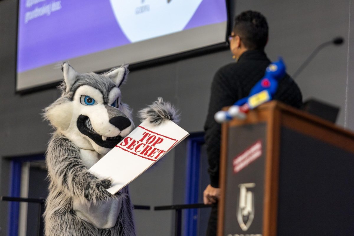 Wiley shows off a paper that says "Top Secret" to Dr. Namuo at the State of the College Address where the new logo was first announced.