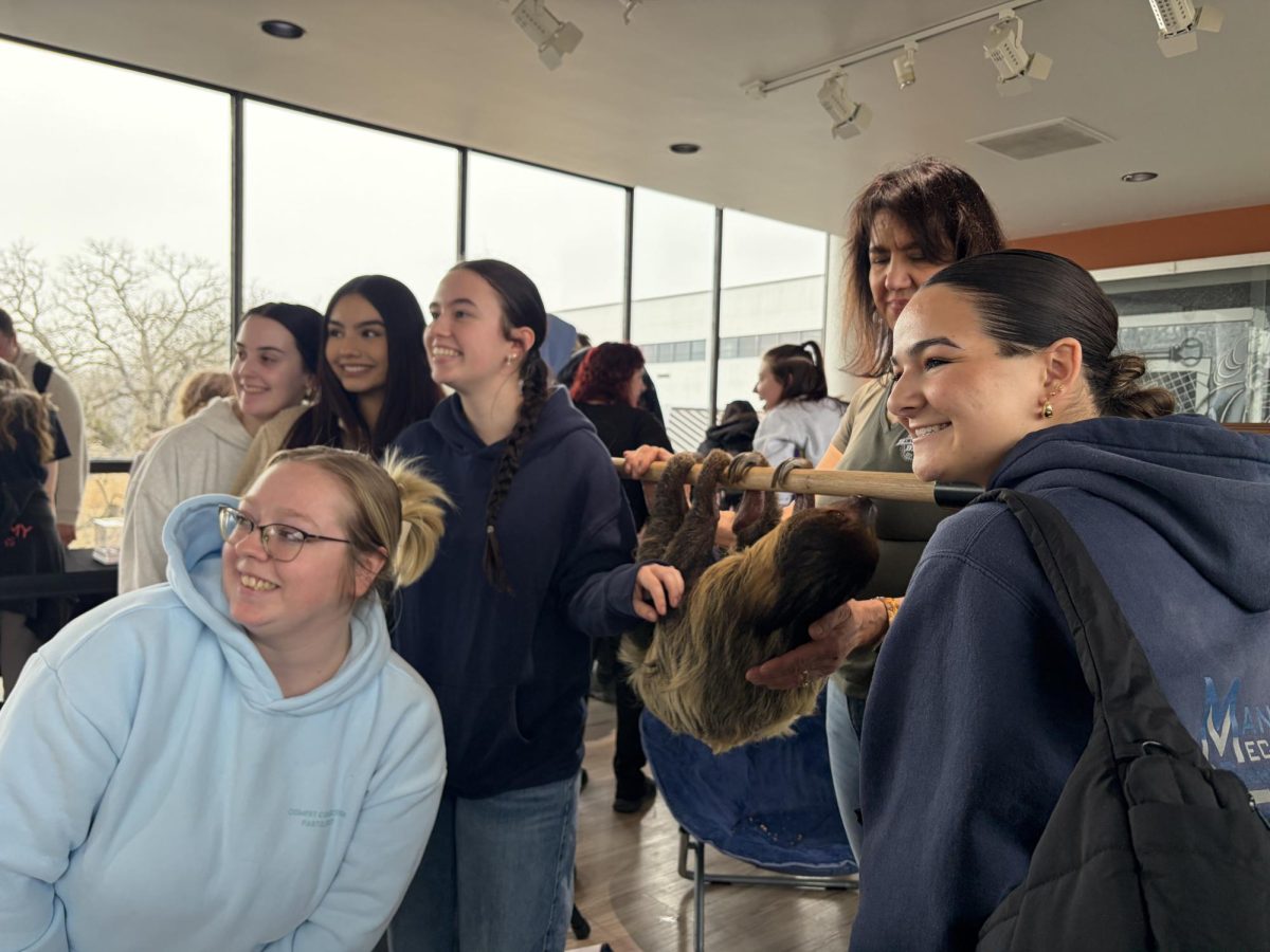 Students posing for a picture with a sloth at the Animal Show and Meet and Greet on Wed. March 4, 2026 from 11:00 a.m.-1:00 p.m. at the H-Center Bridge.