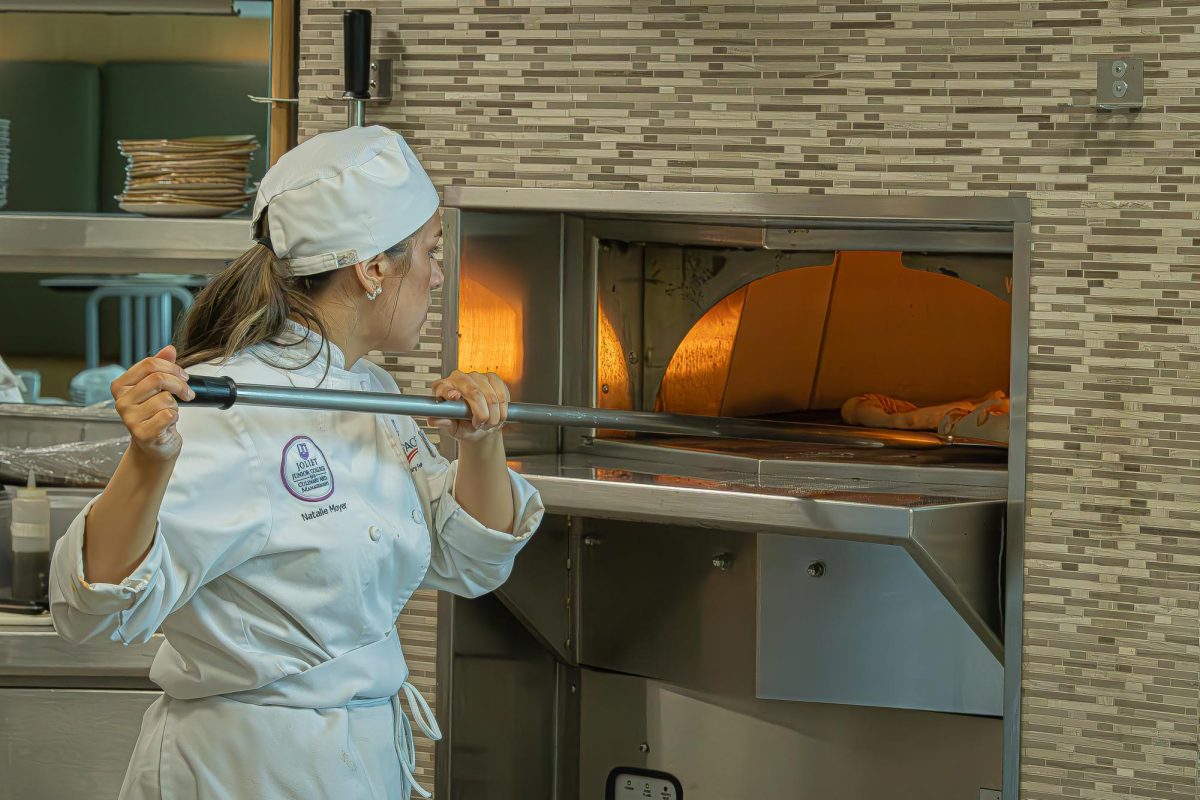 Culinary student Natalie Moyer works in the pizza oven at the student run restaurant Thrive on April 22, 2026.