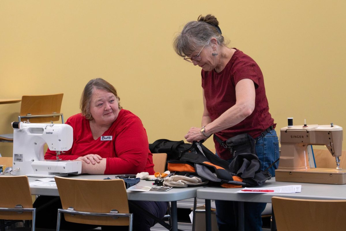 Karen Fonte and Barb Lindblom discussing fixing a sewing job on a bag at the Repair Cafe at Romeoville campus on April 18, 2026.