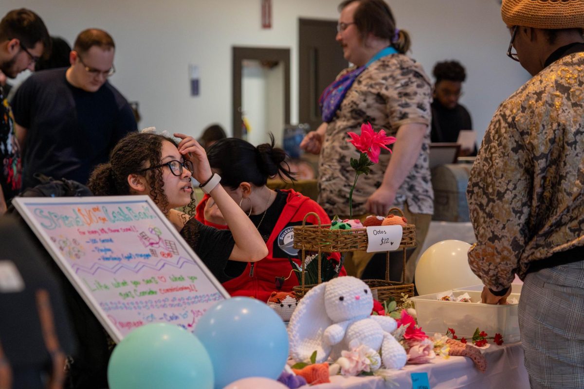 A potential customer searching through a student vendor's crafts Student vendor speaking her artwork with a customer at the craft fair on Wednesday, April 22, 2026.