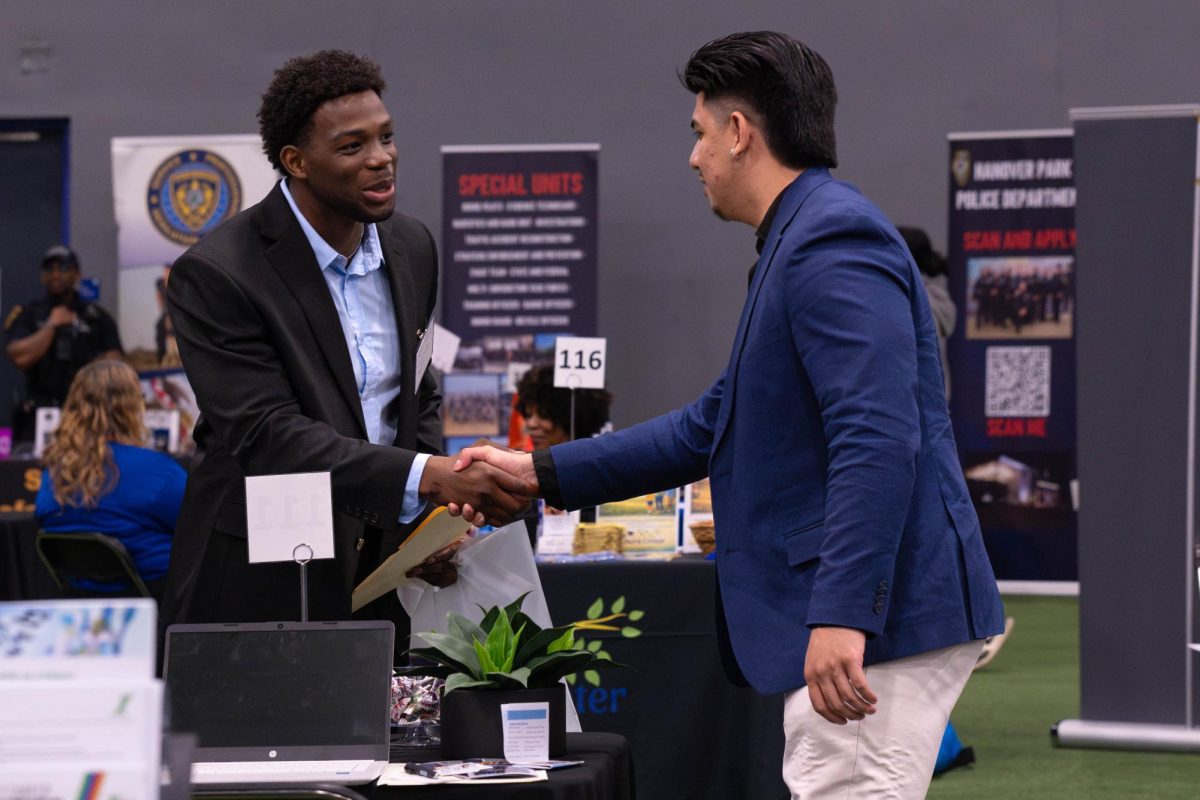 Student Alexander Ogugua shaking hands with a representative from The Radu Group: Globe Life Liberty National Division at the Joliet Regional Career & College Fair on March 26, 2026.